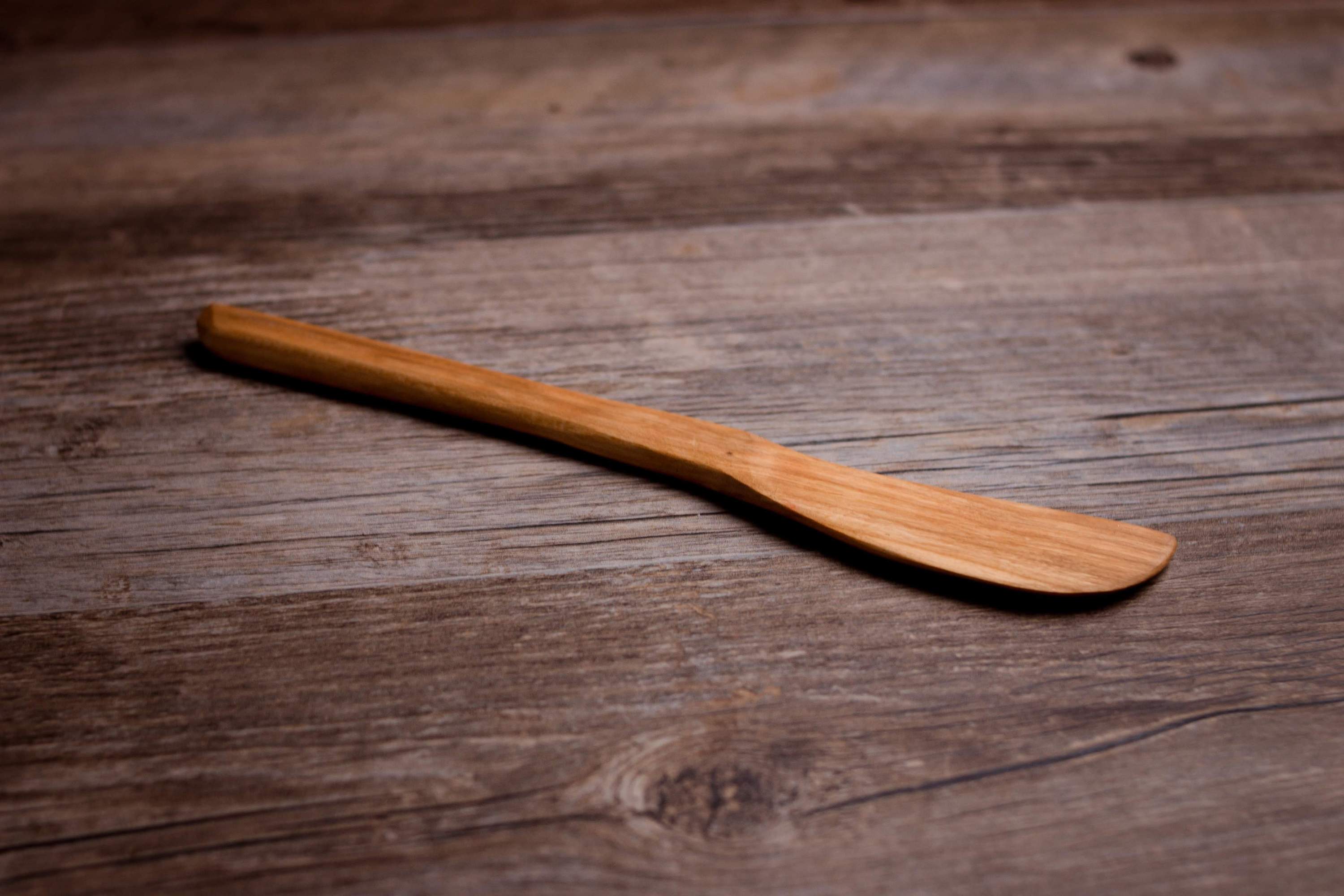 A high-quality wooden baking spatula with a short beveled blade and smooth handle, finished with organic olive oil and beeswax.