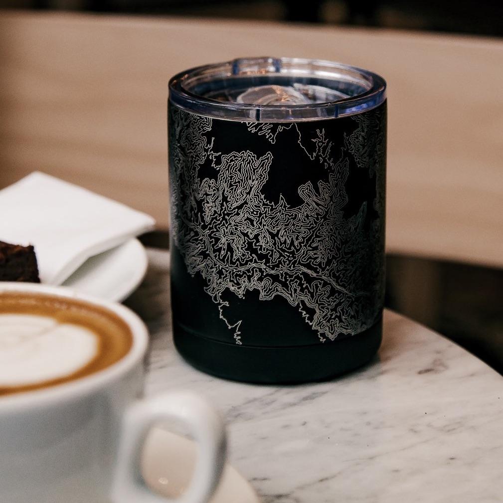 Matte black insulated cup featuring a custom engraved map of Baltimore, Maryland with coordinates.