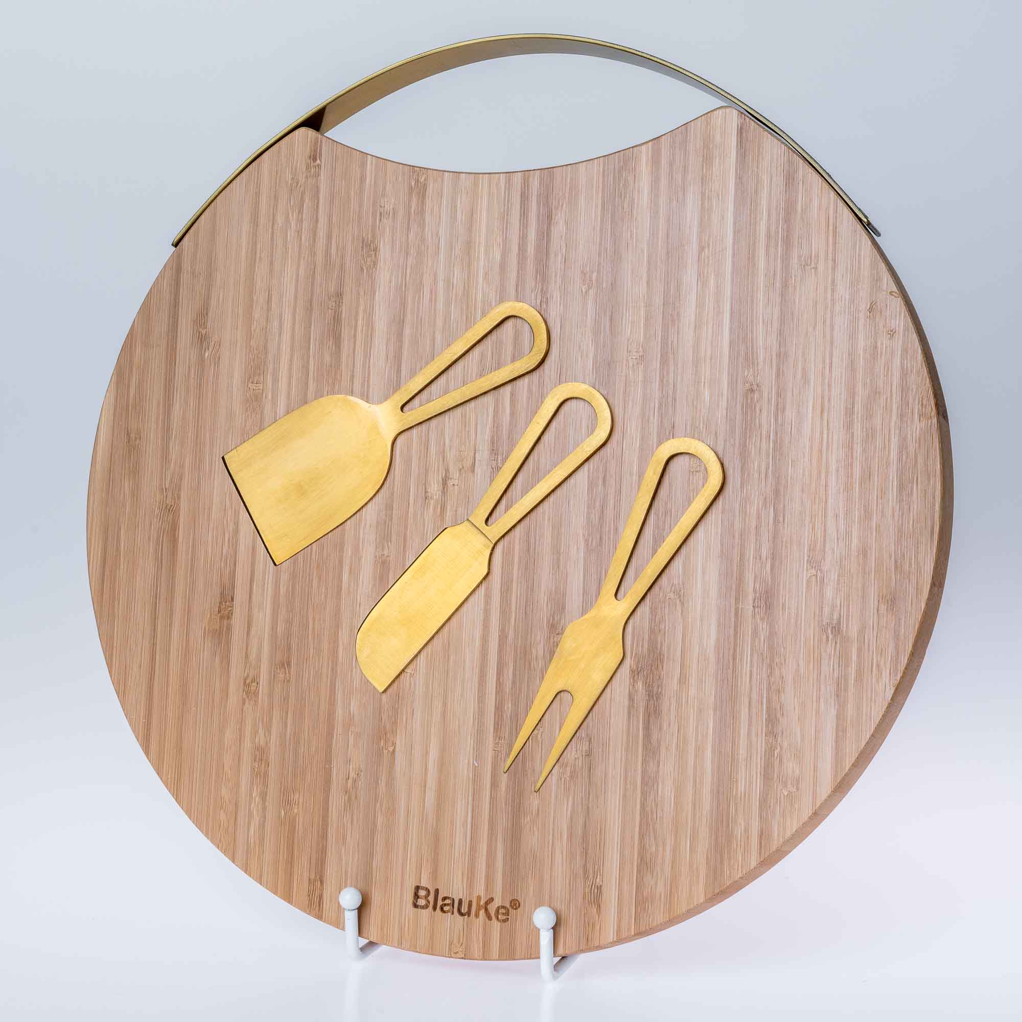 A stylish 13-inch bamboo cheese board with magnetic knife storage, featuring a spatula knife, plane knife, and serving fork, elegantly arranged for serving.