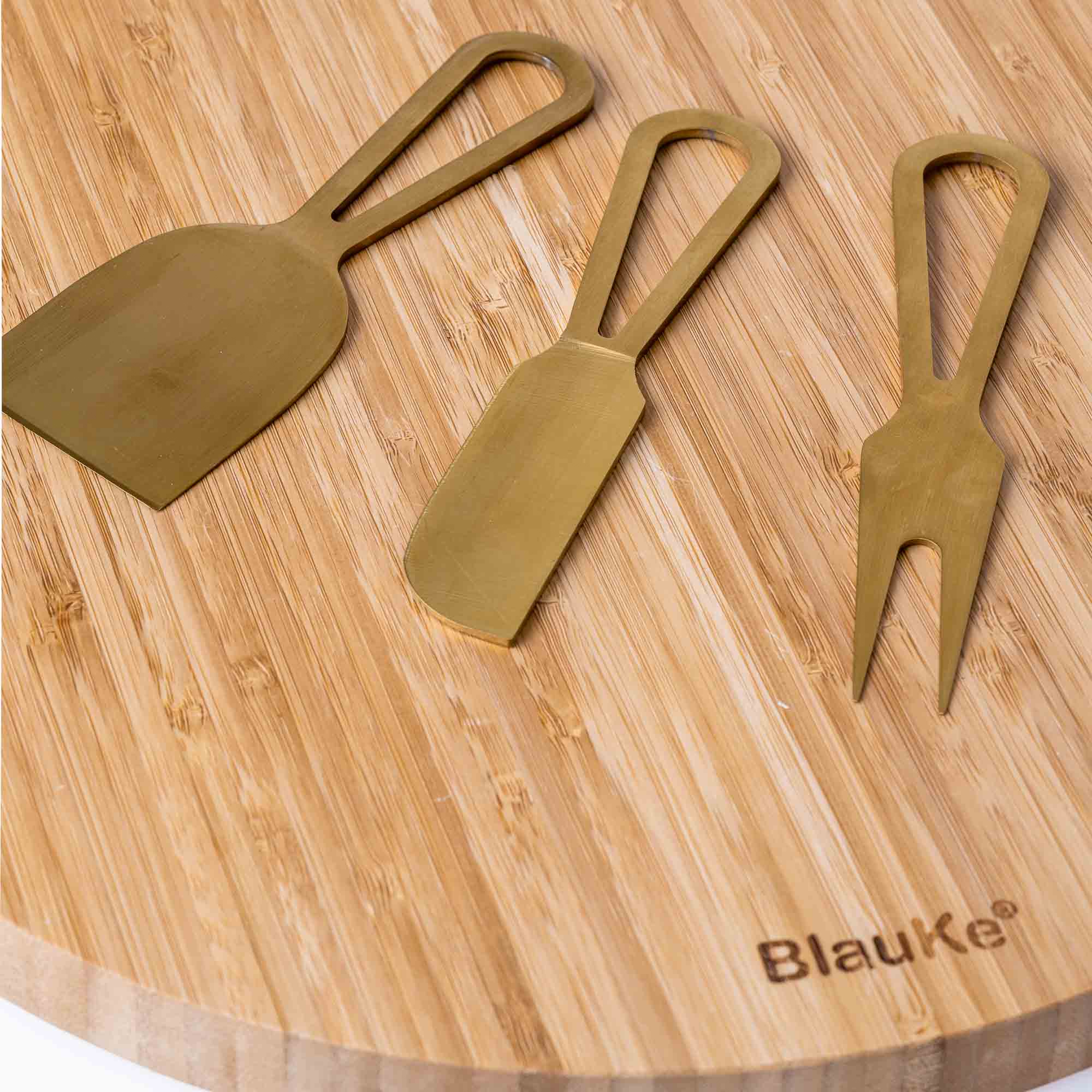 A stylish 13-inch bamboo cheese board with magnetic knife storage, featuring a spatula knife, plane knife, and serving fork, elegantly arranged for serving.