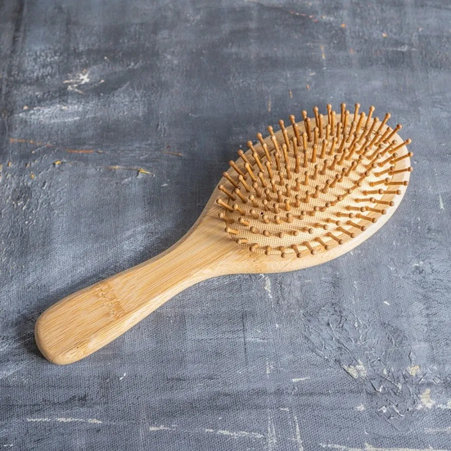 Bamboo Hair Brush Set including a round brush, bamboo comb, and brush cleaner in a reusable travel bag.