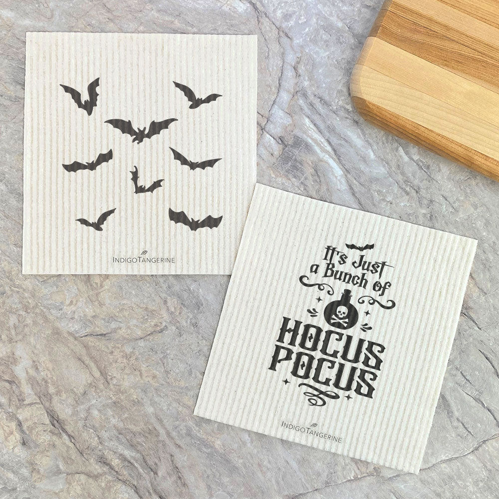 Two eco-friendly Swedish dish cloths featuring a whimsical bats and hocus pocus design, made from plant-based fibers.