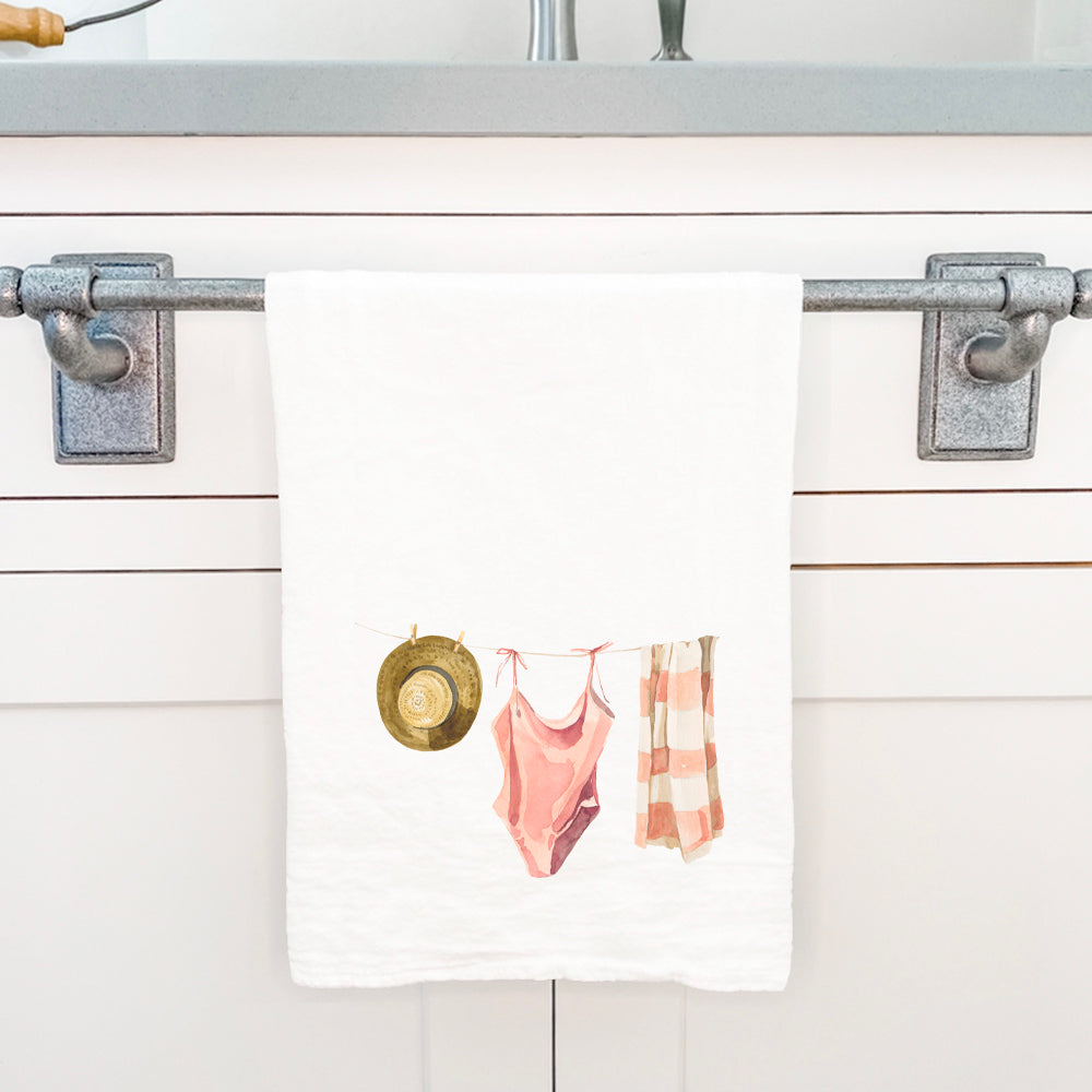 A vibrant cotton tea towel featuring a beach-themed design, showcasing its absorbent texture and hemmed edges, perfect for kitchen use.