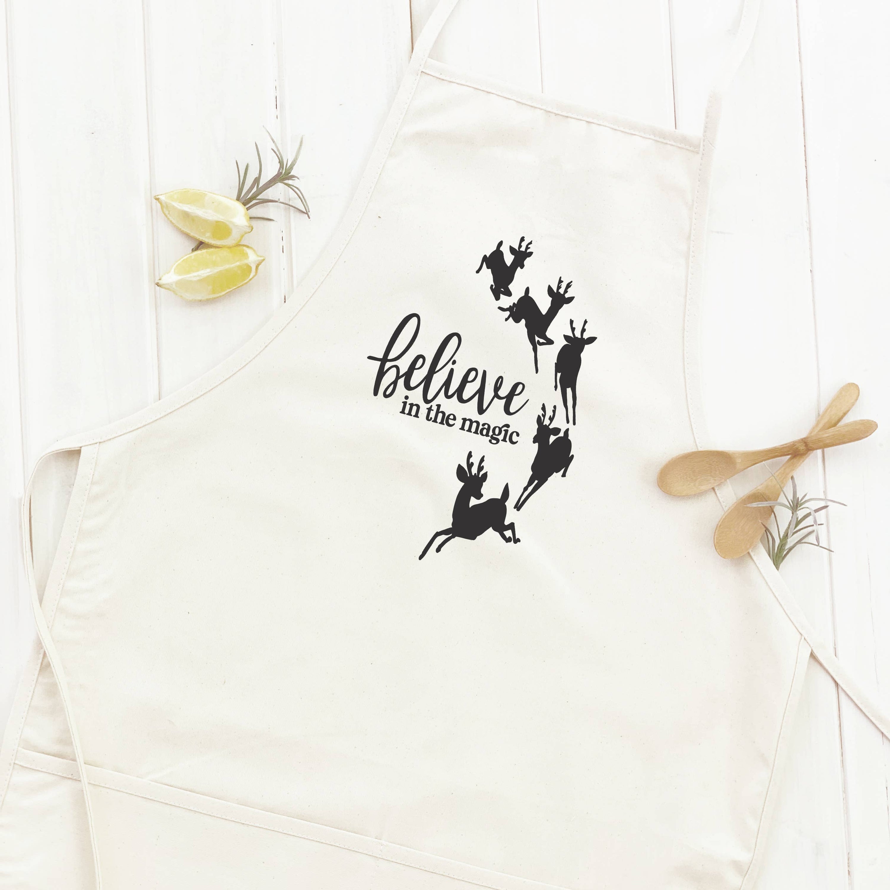 A stylish 'Believe in the Magic' women's apron made of cotton canvas, featuring natural twill ties and a divided front pocket.