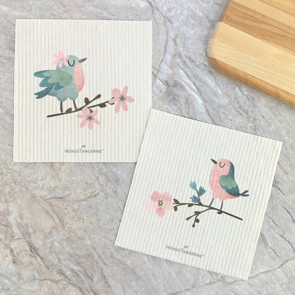 Two Swedish dish cloths featuring birds on flowering branches, eco-friendly and reusable.