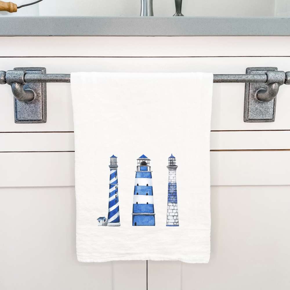 A vibrant blue cotton tea towel featuring a lighthouse design, perfect for kitchen use and decor.