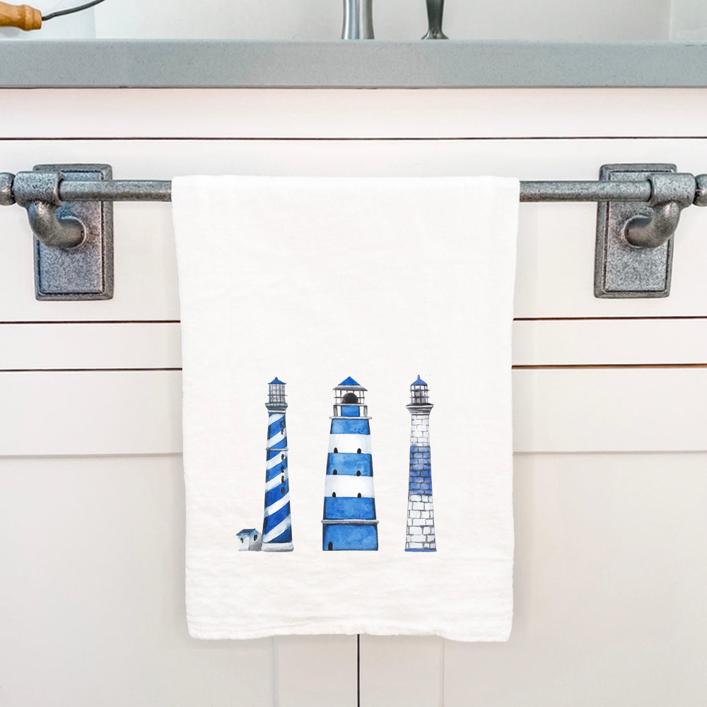 A vibrant blue cotton tea towel featuring a lighthouse design, perfect for kitchen use and decor.