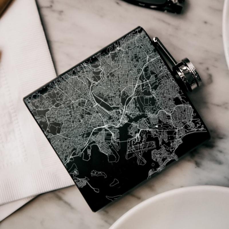 Custom engraved matte black hip flask featuring a detailed map of Boston, Massachusetts with coordinates.