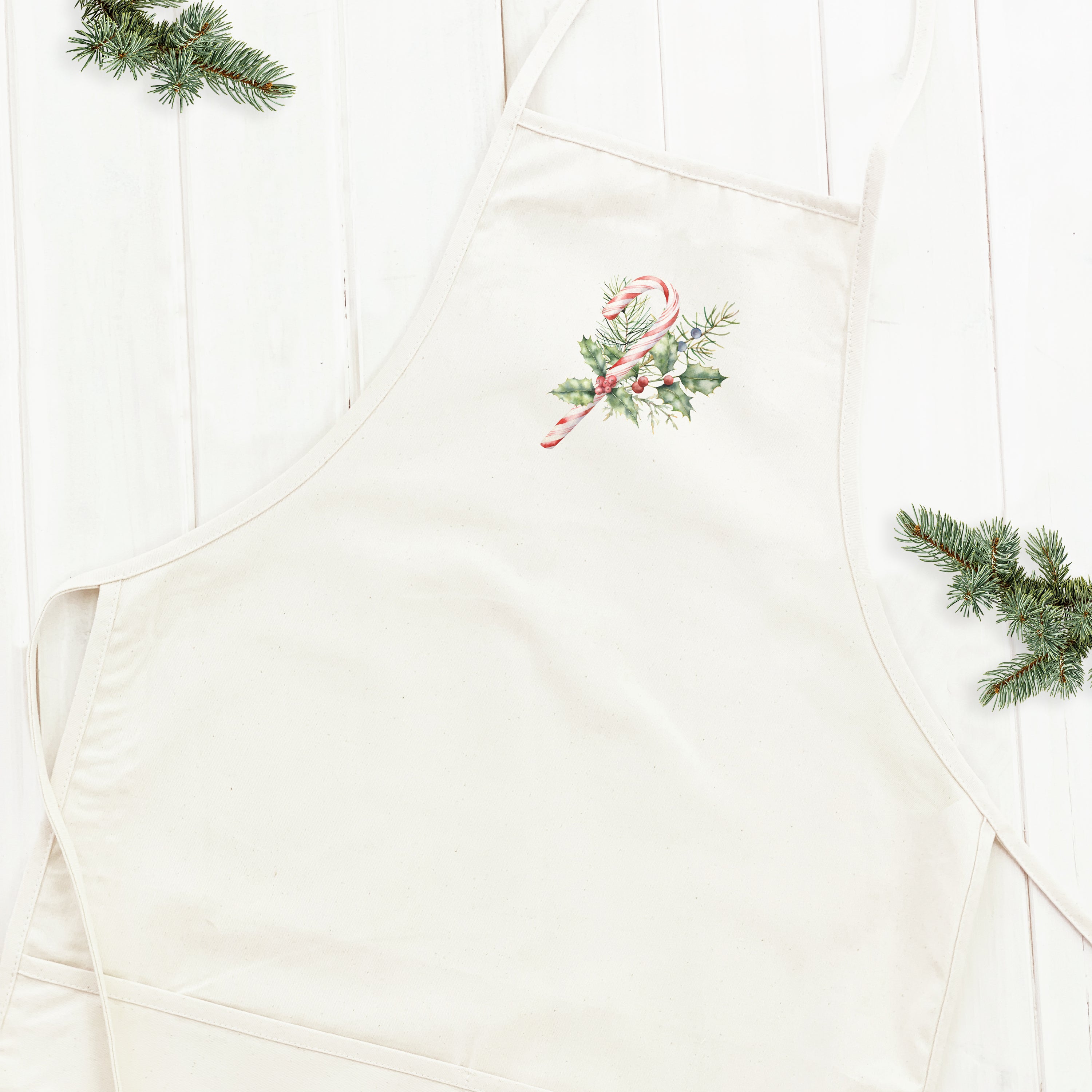 Candy Cane with Holly Women's Apron featuring festive design, adjustable neck strap, and divided front pocket, made from durable cotton canvas.