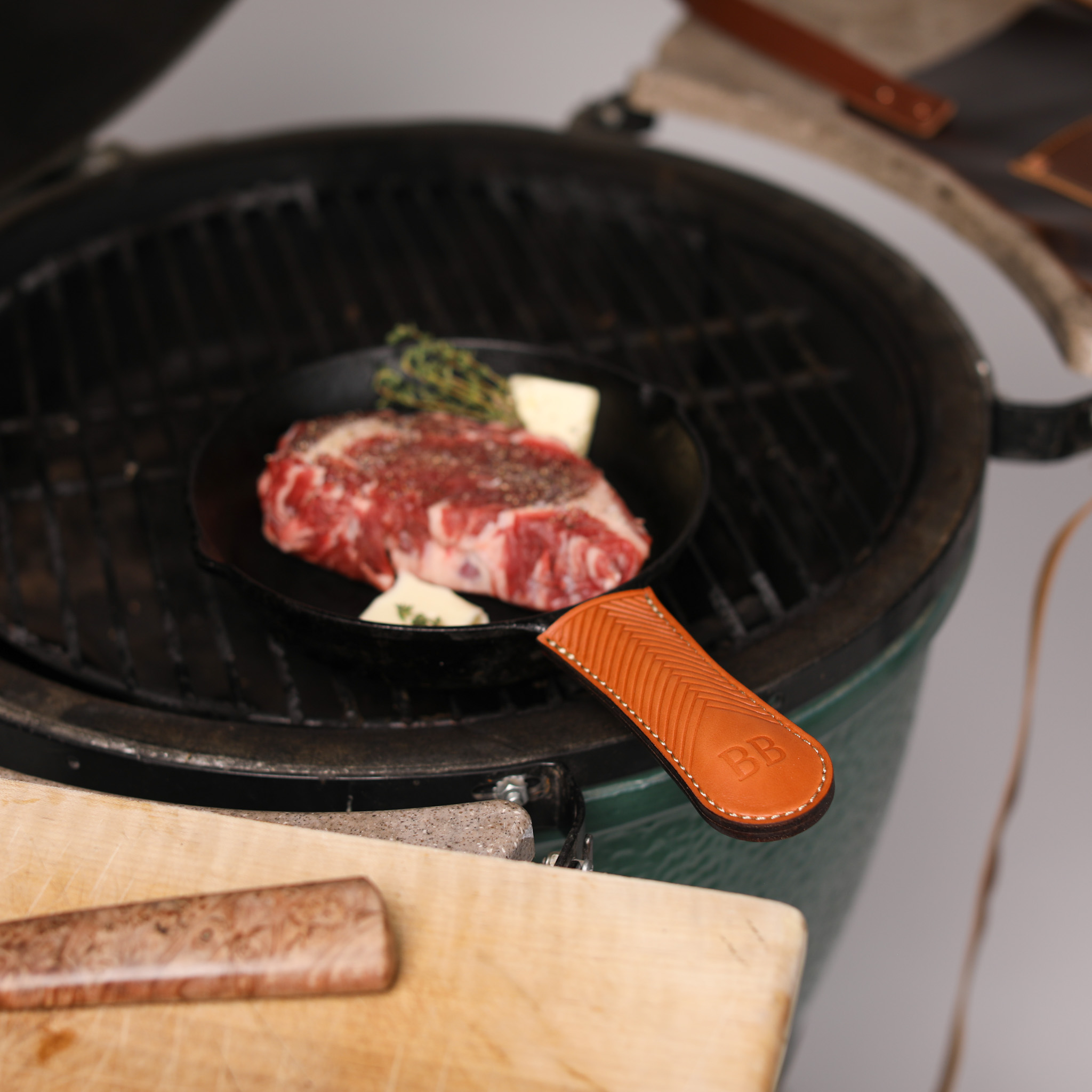 A pair of handcrafted leather cast-iron handle covers, showcasing their elegant design and durable material, perfect for protecting hands while cooking.