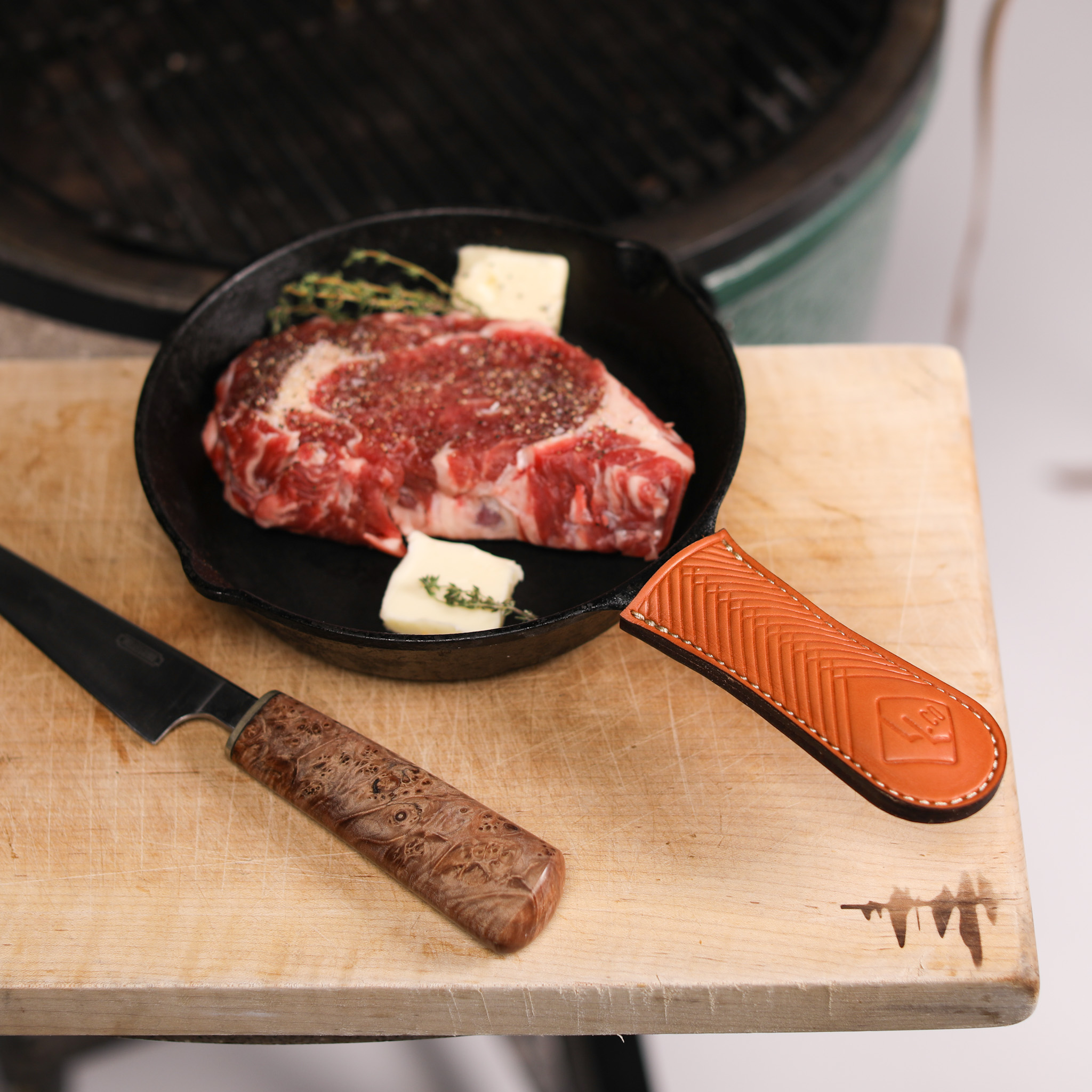 A pair of handcrafted leather cast-iron handle covers, showcasing their elegant design and durable material, perfect for protecting hands while cooking.