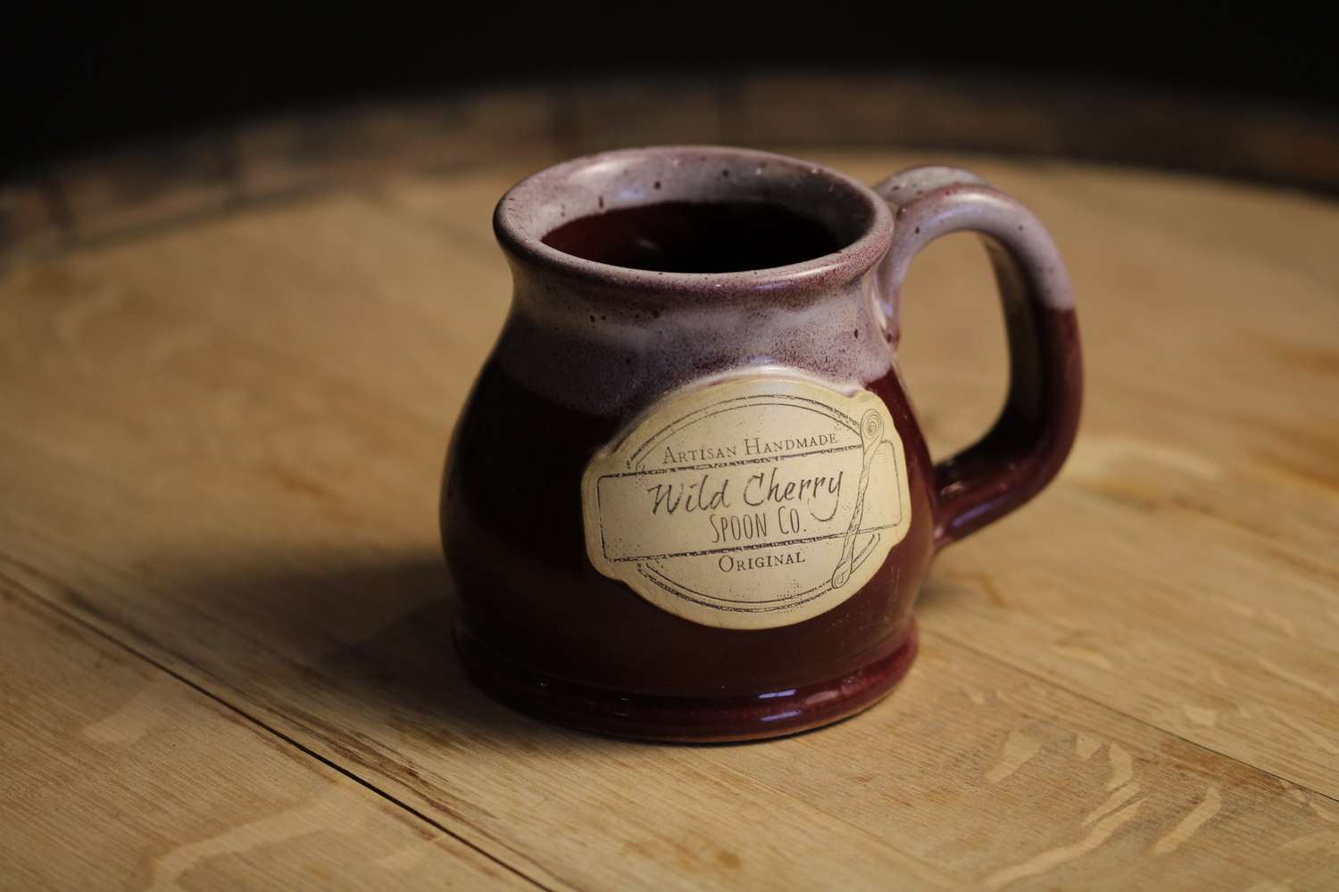 Ceramic Wild Cherry Spoon Co 12 oz Potbelly Coffee Mug with rounded design and logo, perfect for coffee lovers.