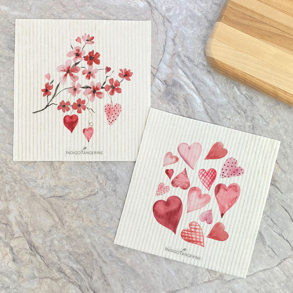 Two Swedish dish cloths featuring a Cherry Blossom Branch design with scattered hearts, eco-friendly and reusable.