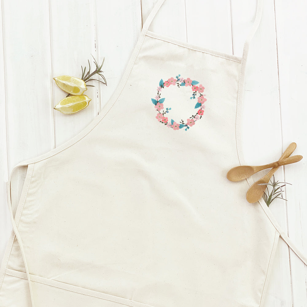 Cherry Blossom Wreath Women's Apron featuring a floral design, adjustable neck strap, and divided front pocket, made from durable cotton canvas.