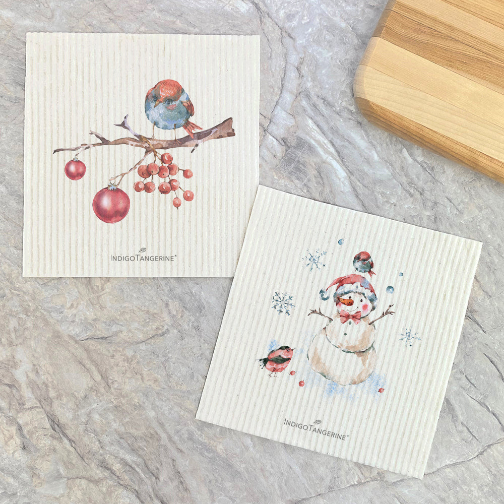 Two Swedish dish cloths featuring Christmas branch and snowman designs, eco-friendly and reusable.