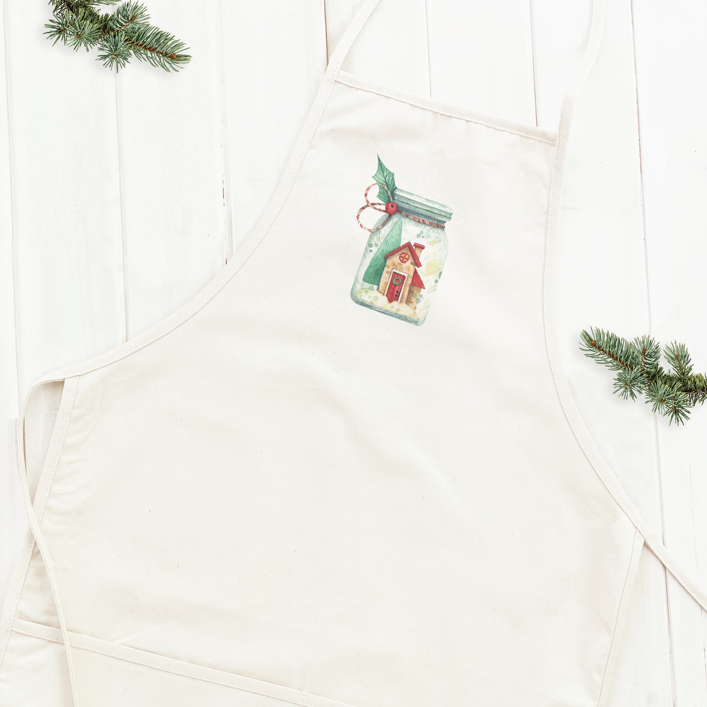 Christmas Snow Jar Women's Apron featuring a festive design, adjustable neck ties, and a divided front pocket, made from durable cotton canvas.