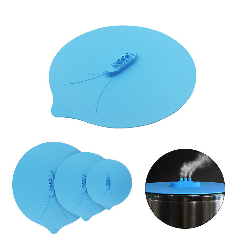 Colorful silicone cooking lid shaped like a ship, designed for kitchen use, featuring three sizes and ear hook for space-saving.