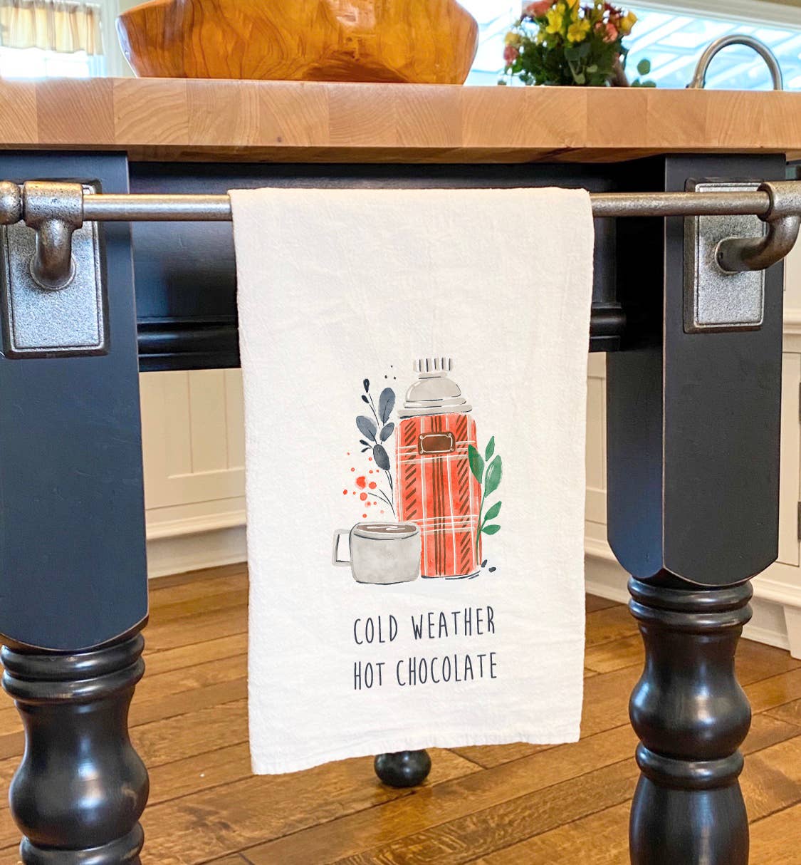 A vibrant cotton tea towel featuring a cozy winter design with hot chocolate, perfect for festive kitchens.