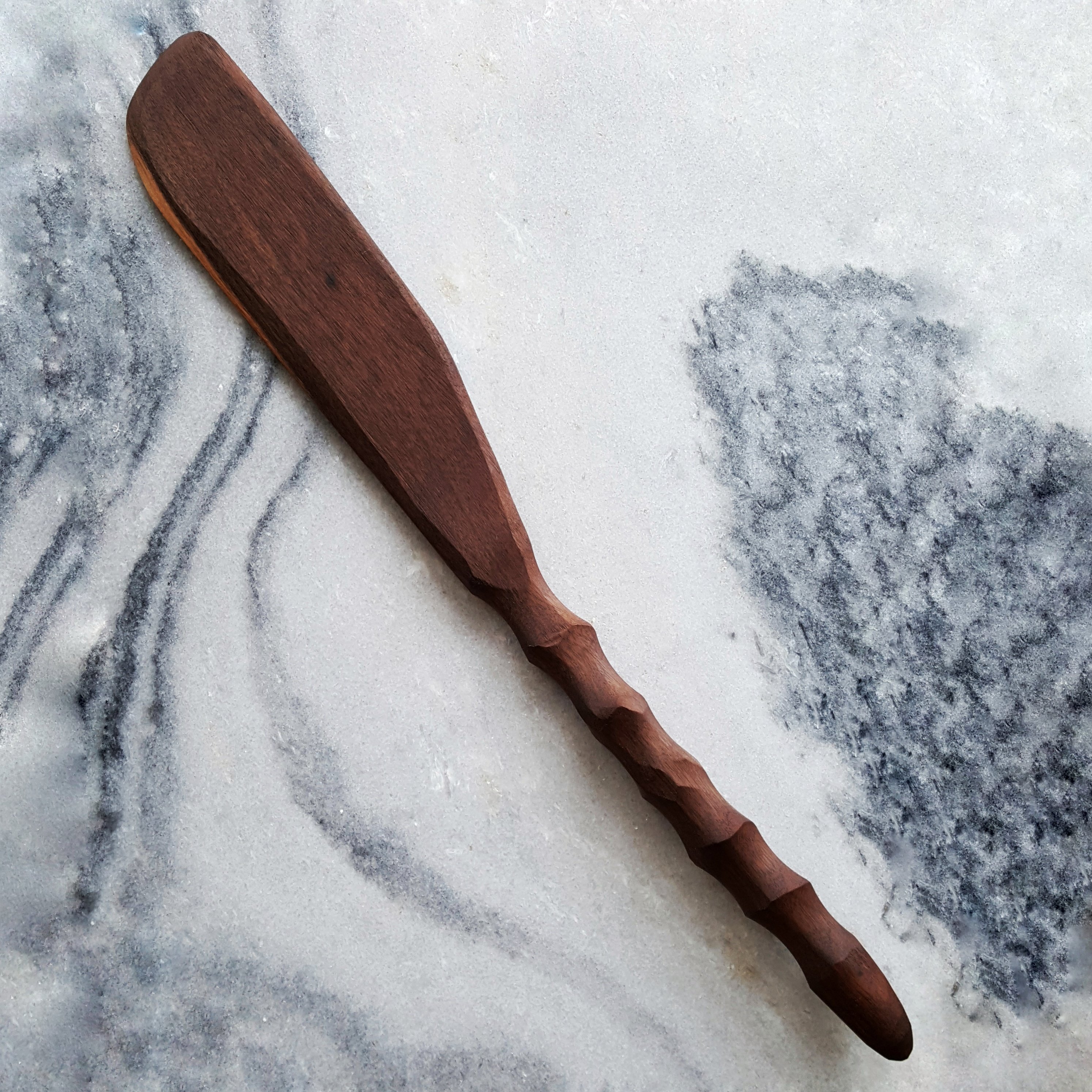 Couthie Spurtle, a flat solid handcarved kitchen tool made from walnut, showcasing its elegant design and craftsmanship.