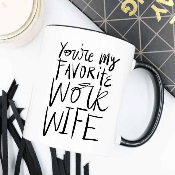 A humorous coffee mug with the text 'You're My Favorite Work Wife' printed on it, showcasing a fun design suitable for office use.