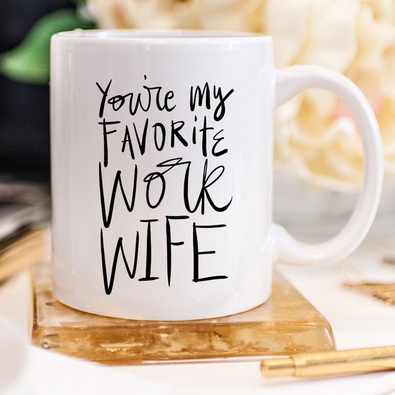 A humorous coffee mug with the text 'You're My Favorite Work Wife' printed on it, showcasing a fun design suitable for office use.