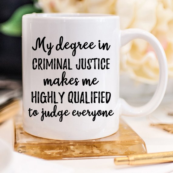 A stylish white ceramic mug featuring a vibrant criminal justice design, suitable for coffee or tea.