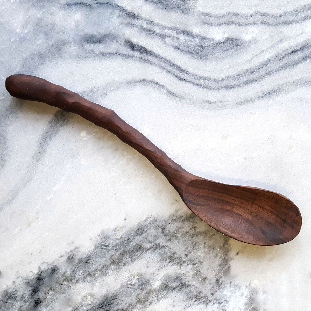 Curvy Ergonomic Cooking Spoon in Cherry and Walnut finishes, showcasing its comfortable grip and stylish design.