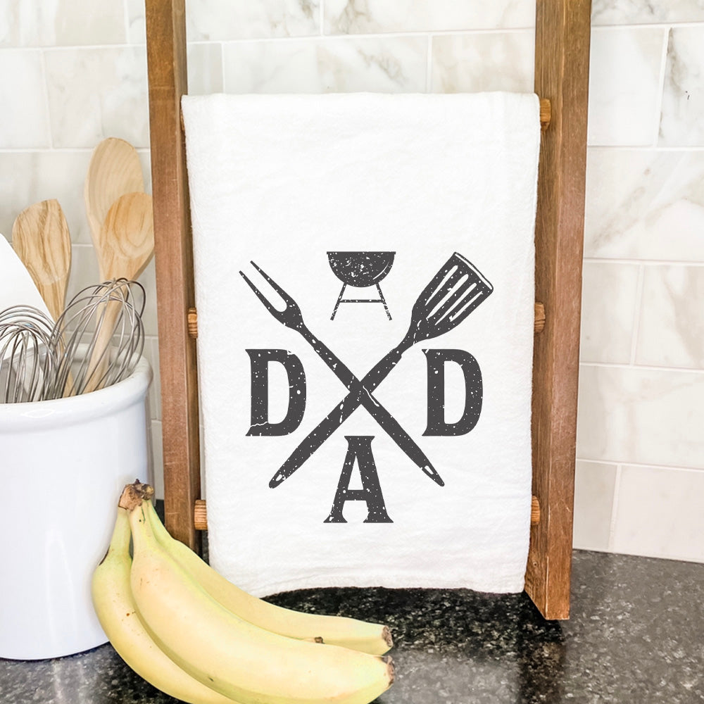 Cotton tea towel featuring a Dad Spatula and Fork design, vibrant colors, and hemmed edges, perfect for kitchen use.