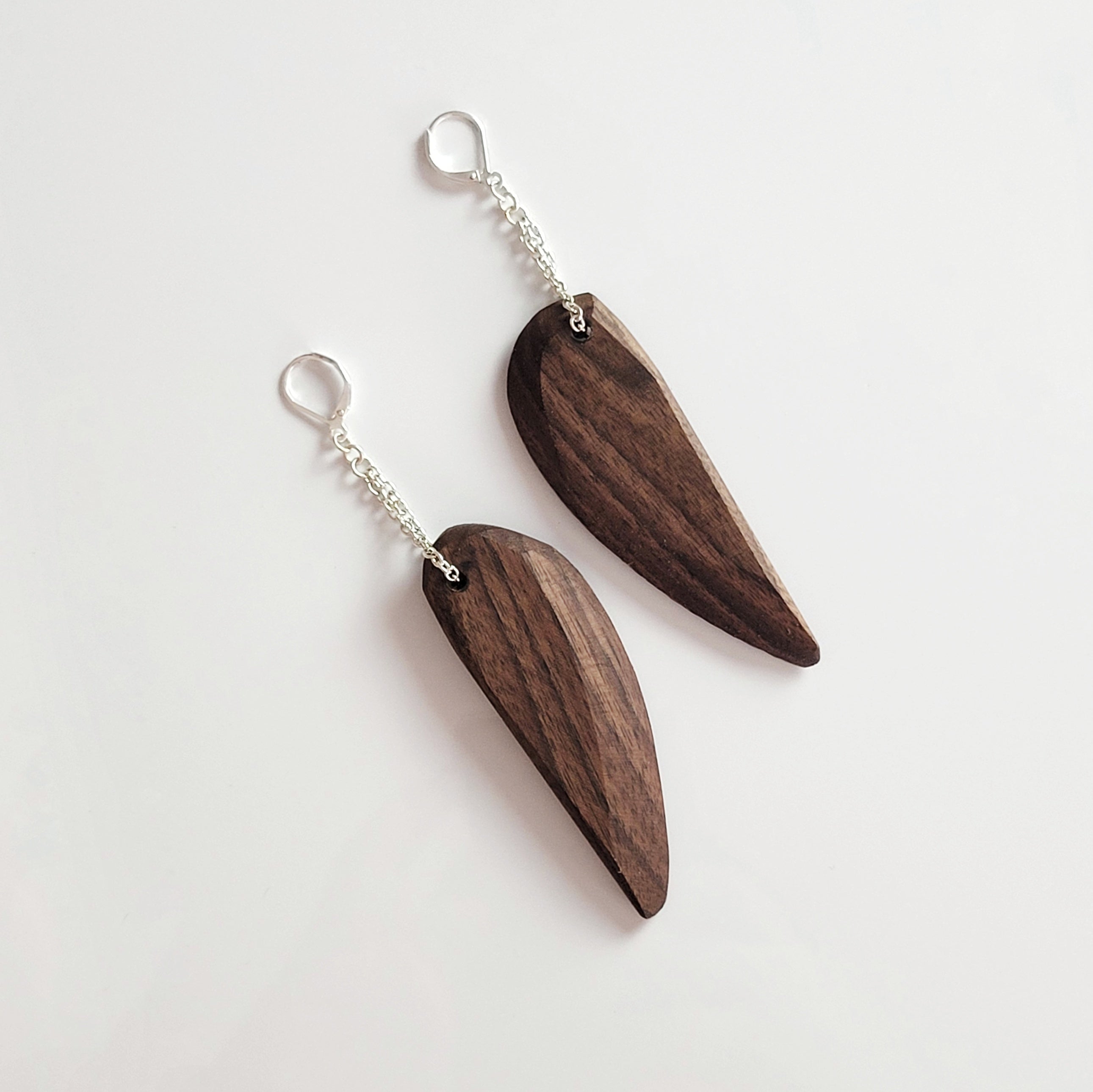 Handmade wooden dangle earrings in feather shape, featuring cherry and walnut finishes with silver plated attachments.