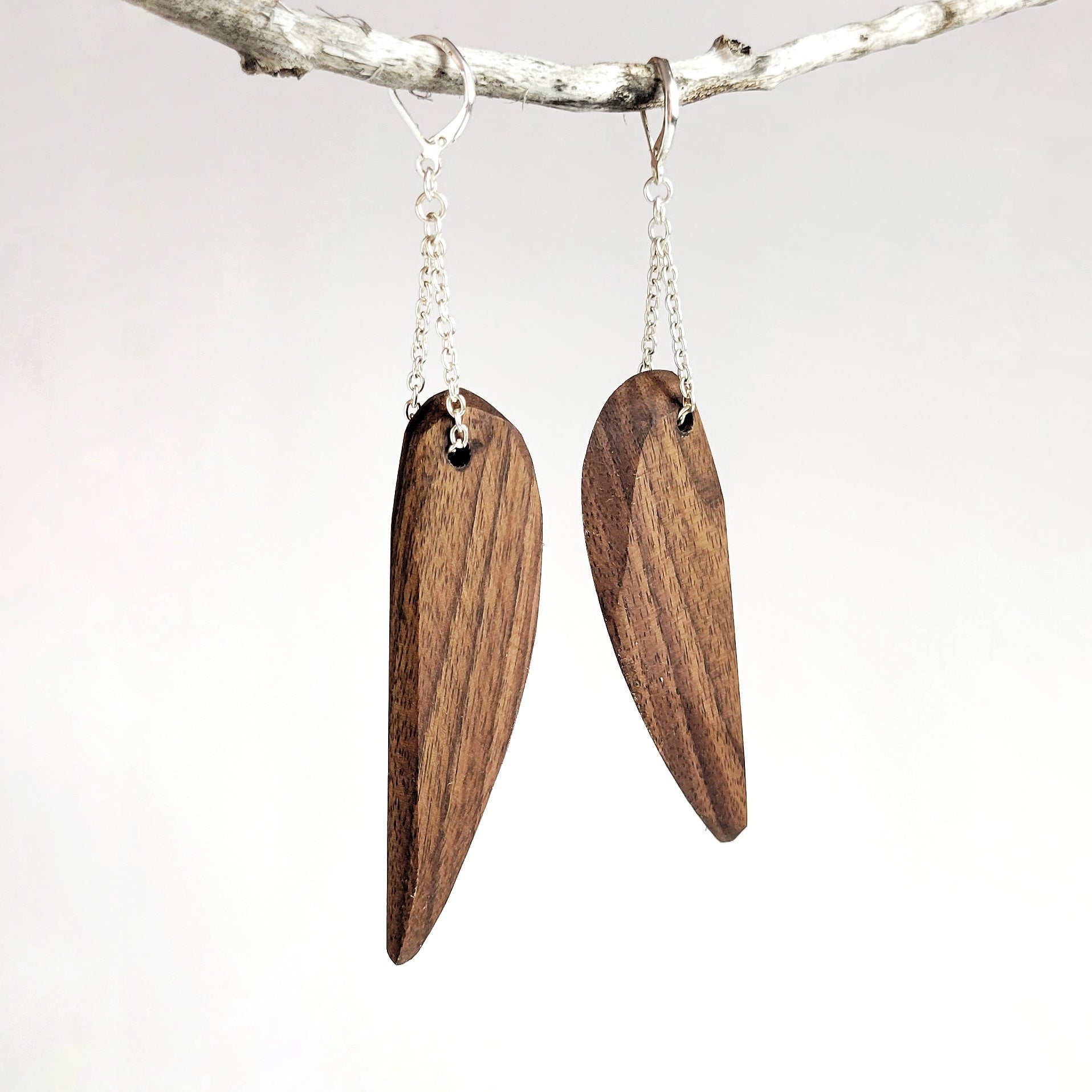 Handmade wooden dangle earrings in feather shape, featuring cherry and walnut finishes with silver plated attachments.