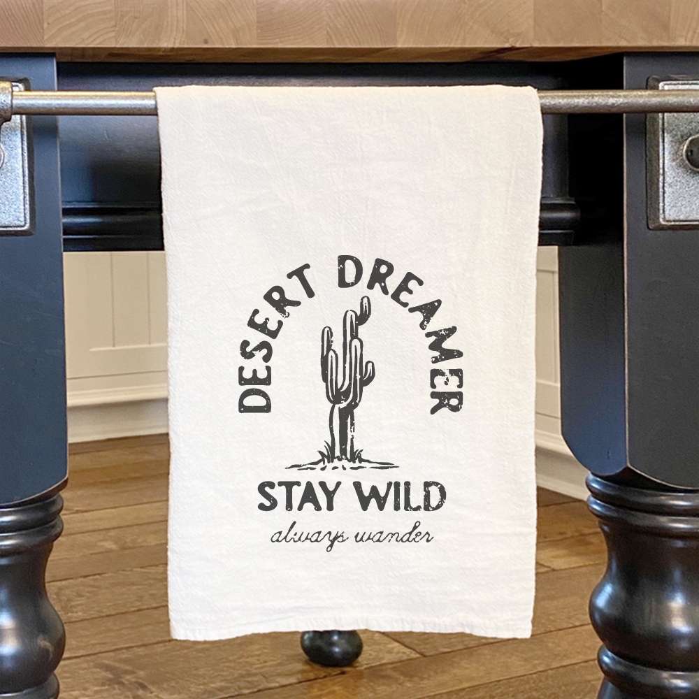 Desert Dreamer Cotton Tea Towel featuring vibrant water-based ink design, 27 inches square, hemmed edges.