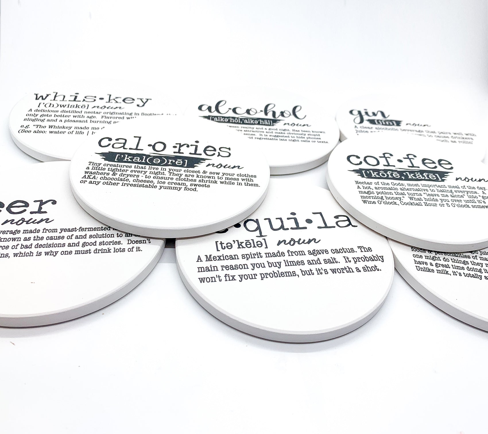 A set of ceramic coasters featuring funny dictionary quotes, showcasing their unique design and cork backing.