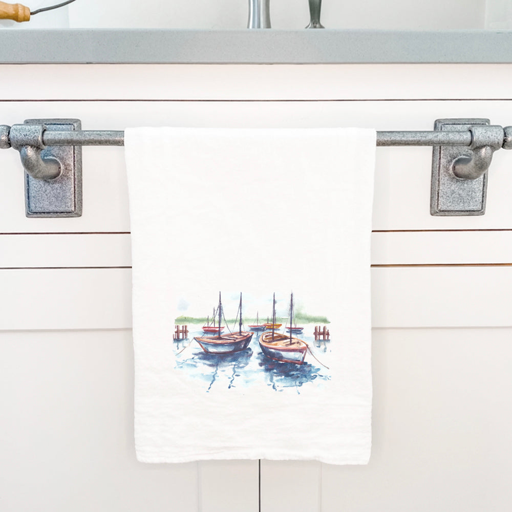 A vibrant cotton tea towel featuring a docked boats design, perfect for kitchen use.