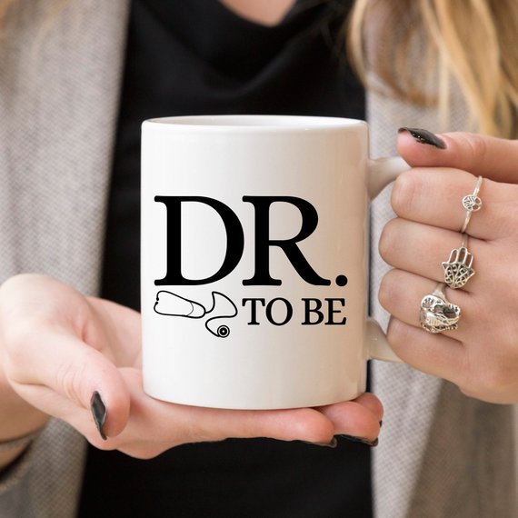 A humorous Dr. To Be coffee mug featuring a witty design, perfect for medical students and coffee lovers, made from high-quality ceramic.