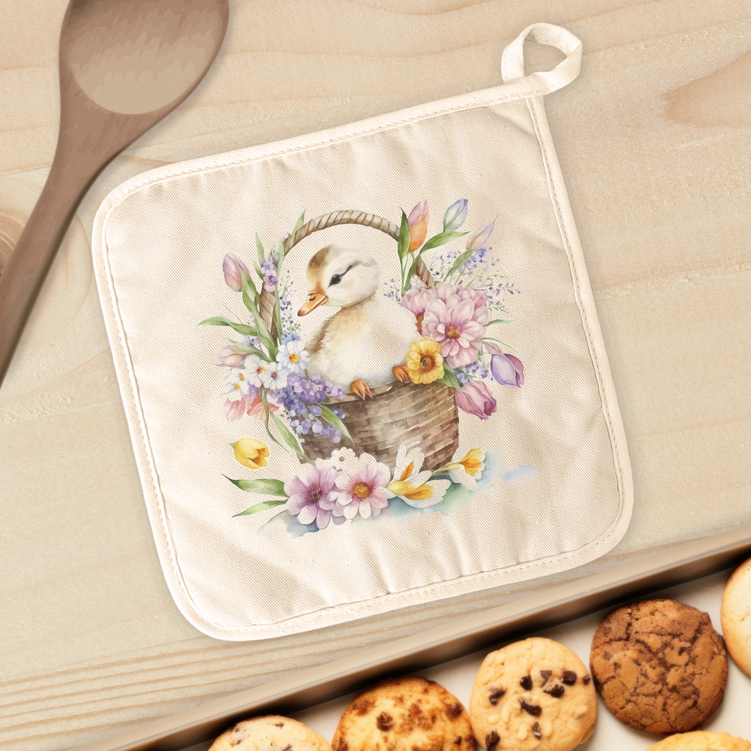 A colorful cotton pot holder featuring a duckling design surrounded by flowers, perfect for protecting surfaces from hot cookware.