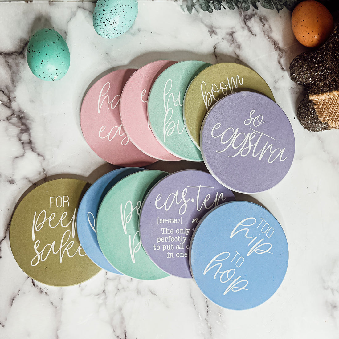 A set of colorful ceramic coasters featuring Easter and spring designs, showcasing a matte finish and cork backing for protection.