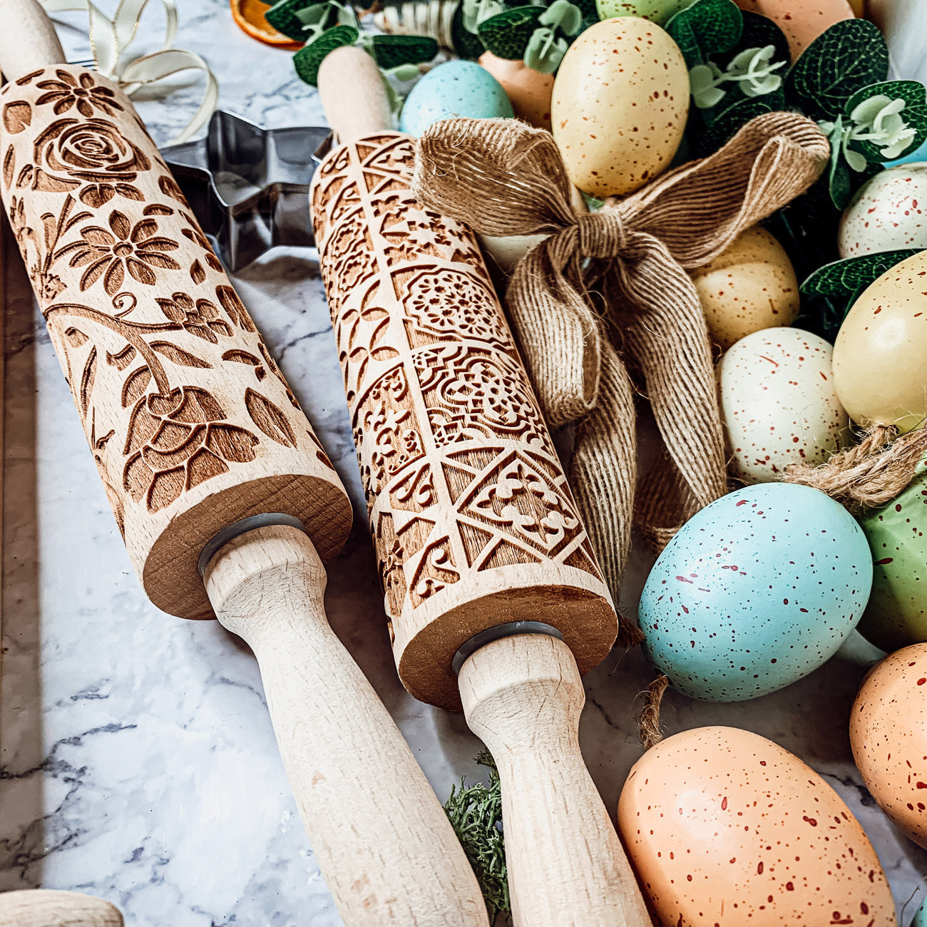 Colorful Easter and Spring rolling pins with floral and bunny designs, accompanied by two metal cookie cutters, perfect for festive baking.