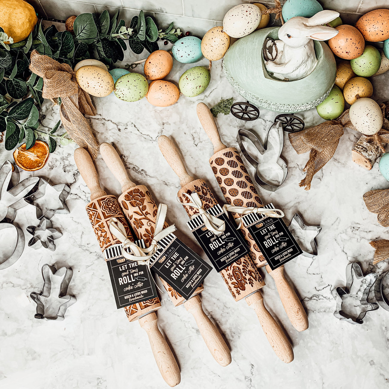 Colorful Easter and Spring rolling pins with floral and bunny designs, accompanied by two metal cookie cutters, perfect for festive baking.