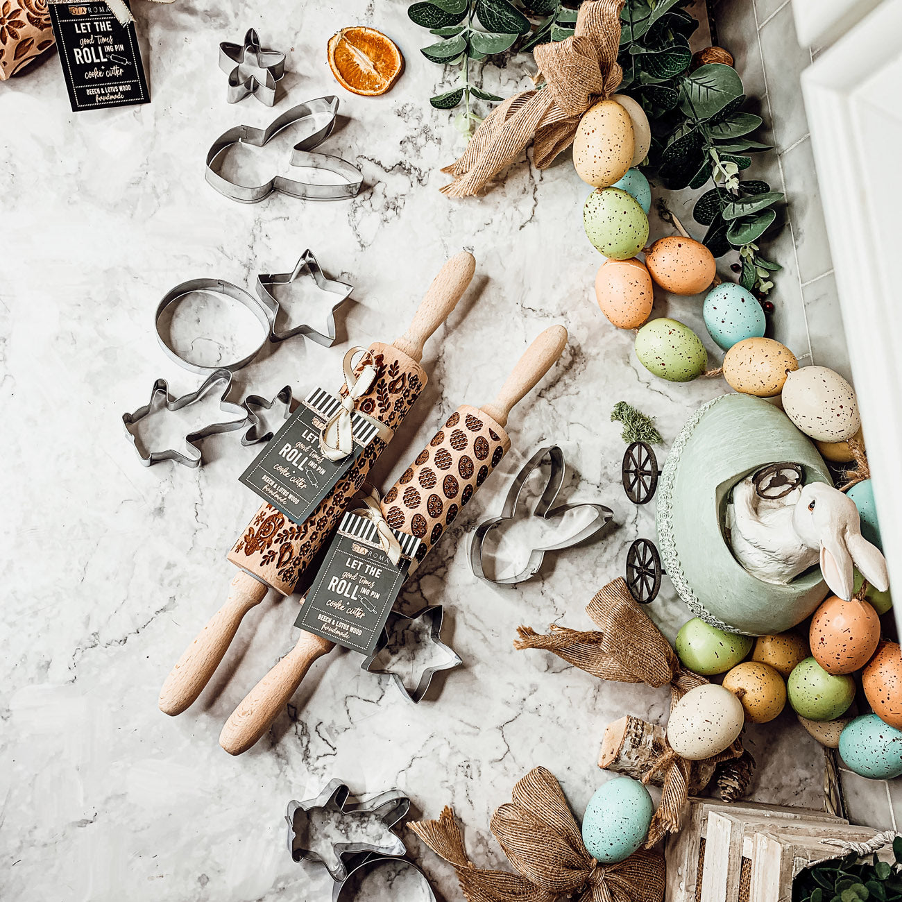 Colorful Easter and Spring rolling pins with floral and bunny designs, accompanied by two metal cookie cutters, perfect for festive baking.