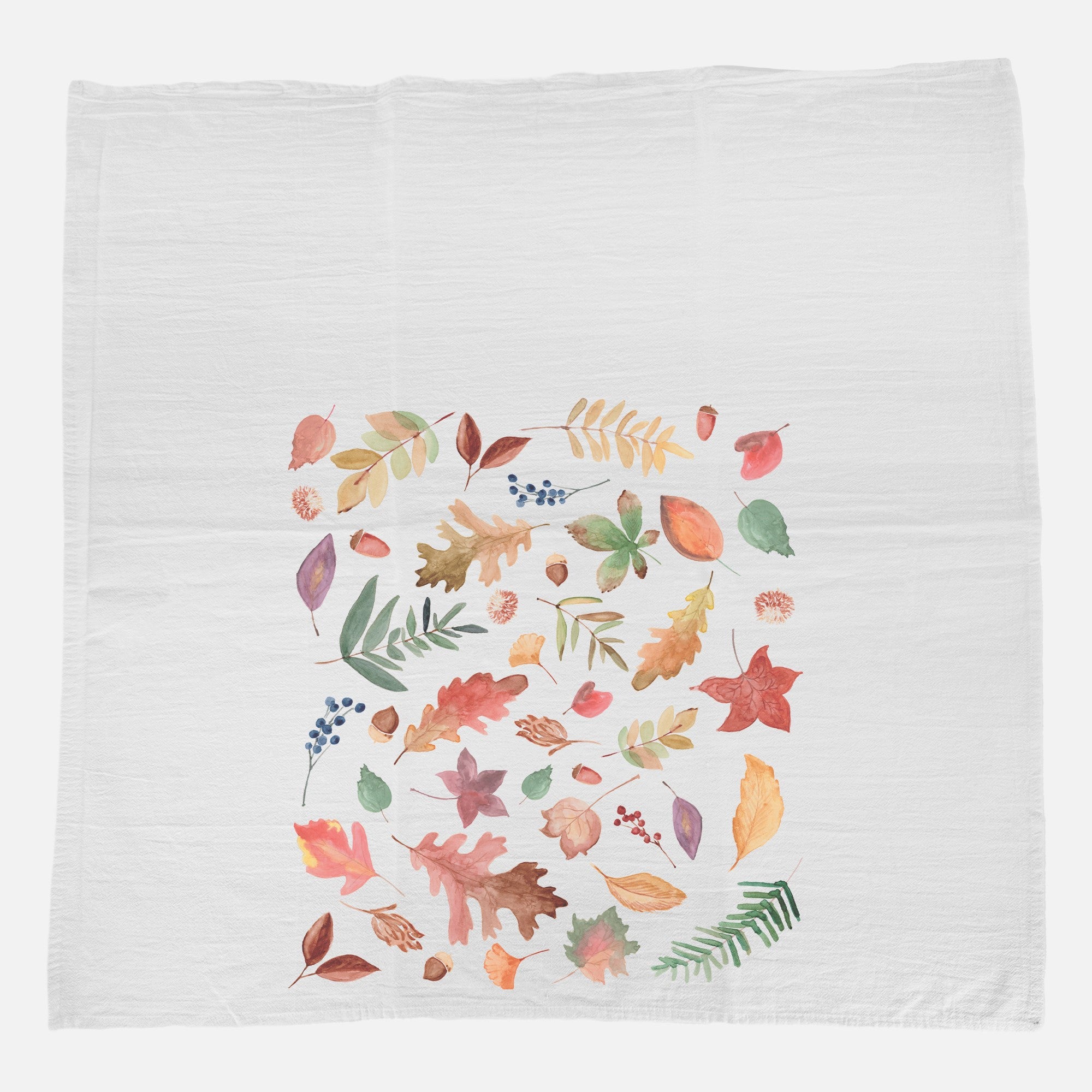 A vibrant cotton tea towel featuring a fall leaves pattern, showcasing rich autumn colors and hemmed edges, perfect for kitchen use.