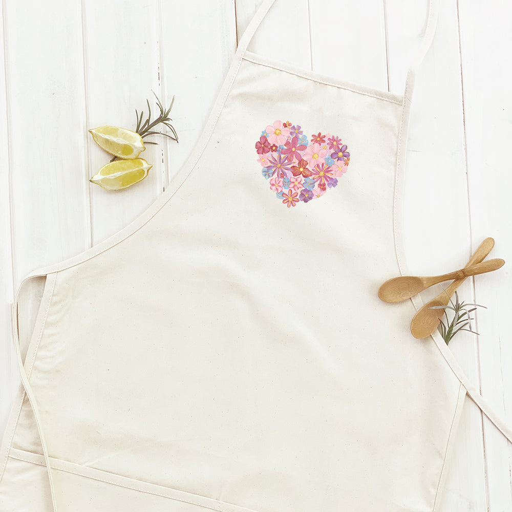 Floral Heart Women's Apron featuring a vibrant floral design, adjustable neck strap, and divided front pocket, made from durable cotton canvas.