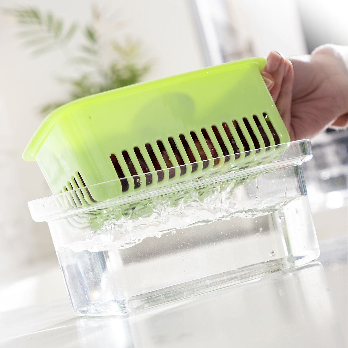 Plastic strainer container being rinsed.