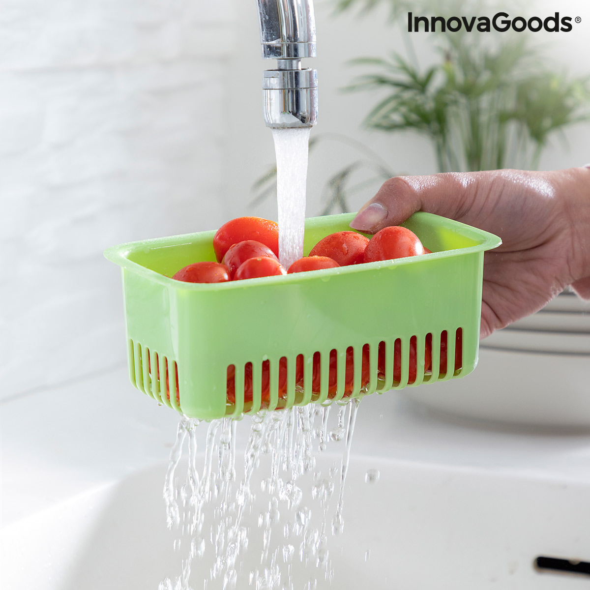 Washing tomatoes in green colander.