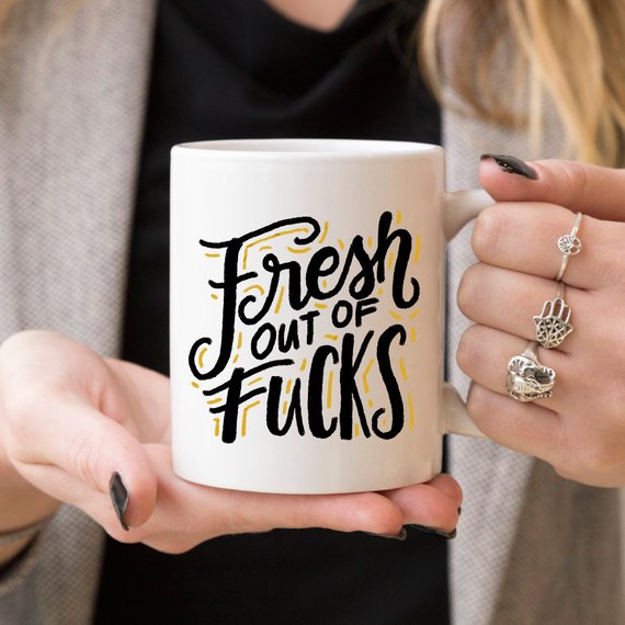 A humorous coffee mug with the phrase 'Fresh Out Of F*cks' printed on it, showcasing a fun design perfect for gag gifts.