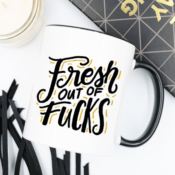 A humorous coffee mug with the phrase 'Fresh Out Of F*cks' printed on it, showcasing a fun design perfect for gag gifts.