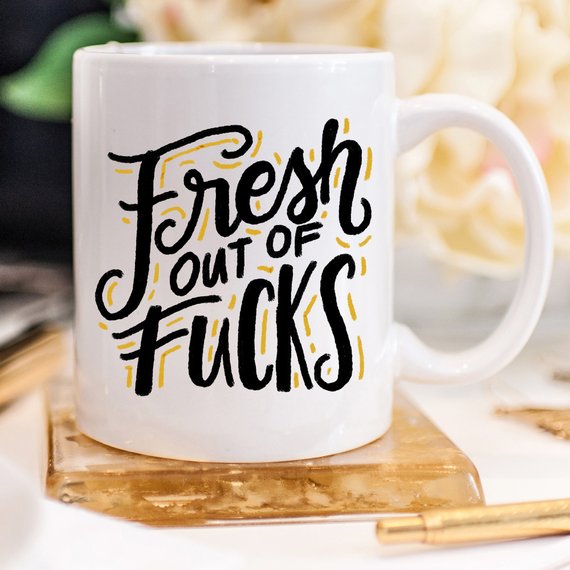 A humorous coffee mug with the phrase 'Fresh Out Of F*cks' printed on it, showcasing a fun design perfect for gag gifts.