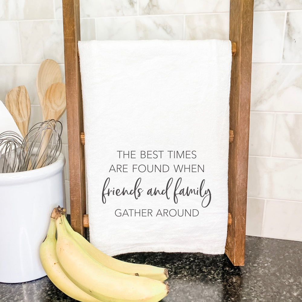 A vibrant cotton tea towel featuring the phrase 'Friends Family Gather Around', designed with colorful water-based inks, perfect for kitchen use.