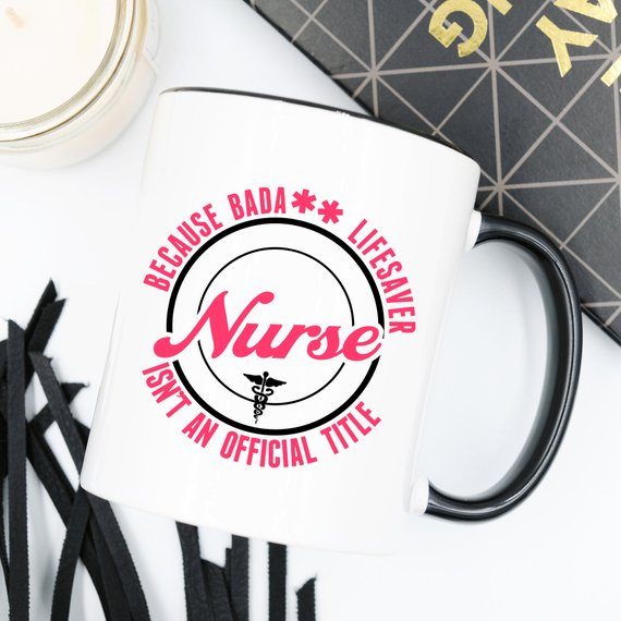 A high-quality white coffee mug featuring the text 'Nurse - Because Bada** Lifesaver Isn't An Official Title' in bold, vivid letters, perfect for nurses.