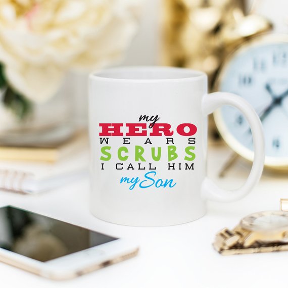 Funny Nurse Mug featuring the text 'My Hero Wears Scrubs, I Call Him My Son', perfect for coffee lovers and nursing professionals.