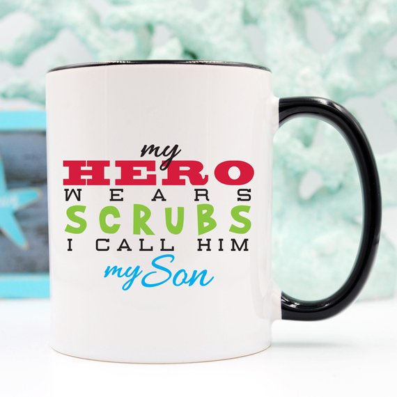 Funny Nurse Mug featuring the text 'My Hero Wears Scrubs, I Call Him My Son', perfect for coffee lovers and nursing professionals.